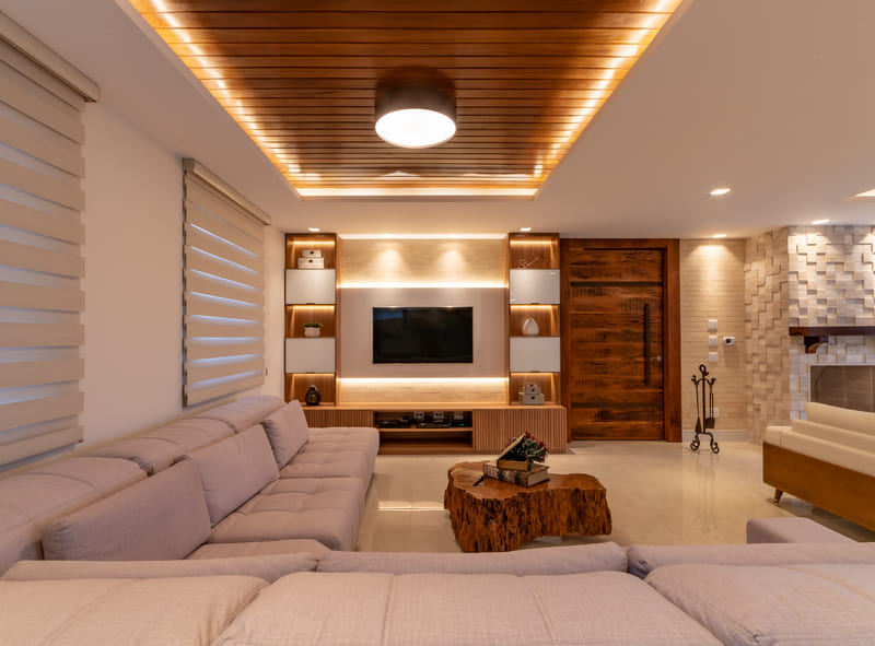 Living room decorated with large sofa and TV panel with LED strips and Accord plafon.