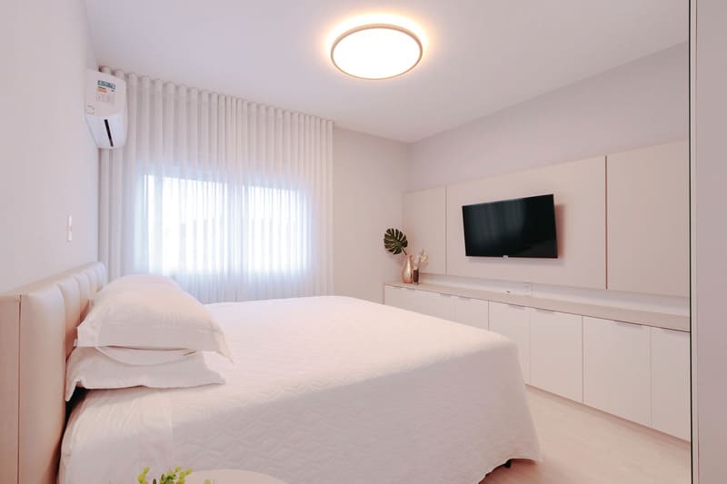 Bedroom with white sheets, curtain and furniture, and an Accord plafon.