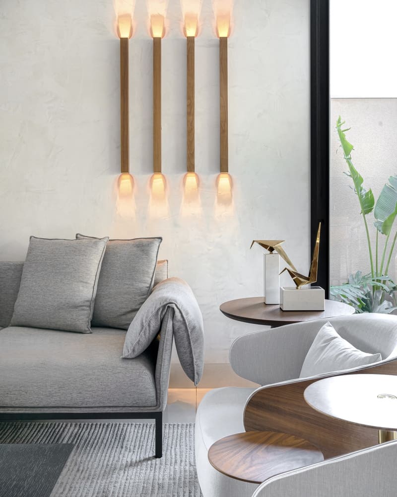 Living room with a sofa and armchairs and vertical Accord sconces.