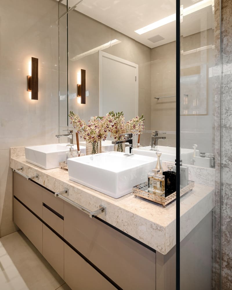 Marble bathroom counter with two sinks, illuminated by an Accord sconce.