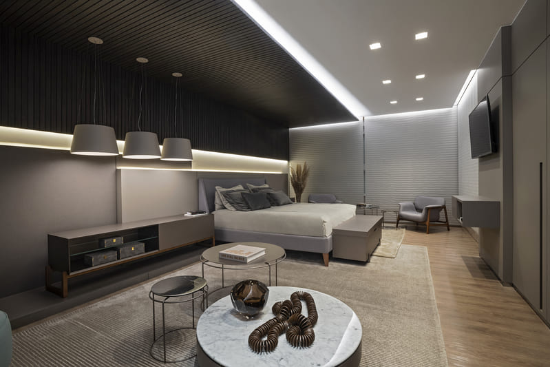 Large bedroom with bed, coffee tables and support furniture, illuminated by plafons, led strips and Accord pendants.